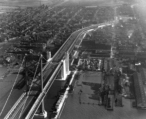 An aerial photograph of the newly completed Benjamin Franklin Bridge in 1926, and the surronding neighborhoods in Camden.