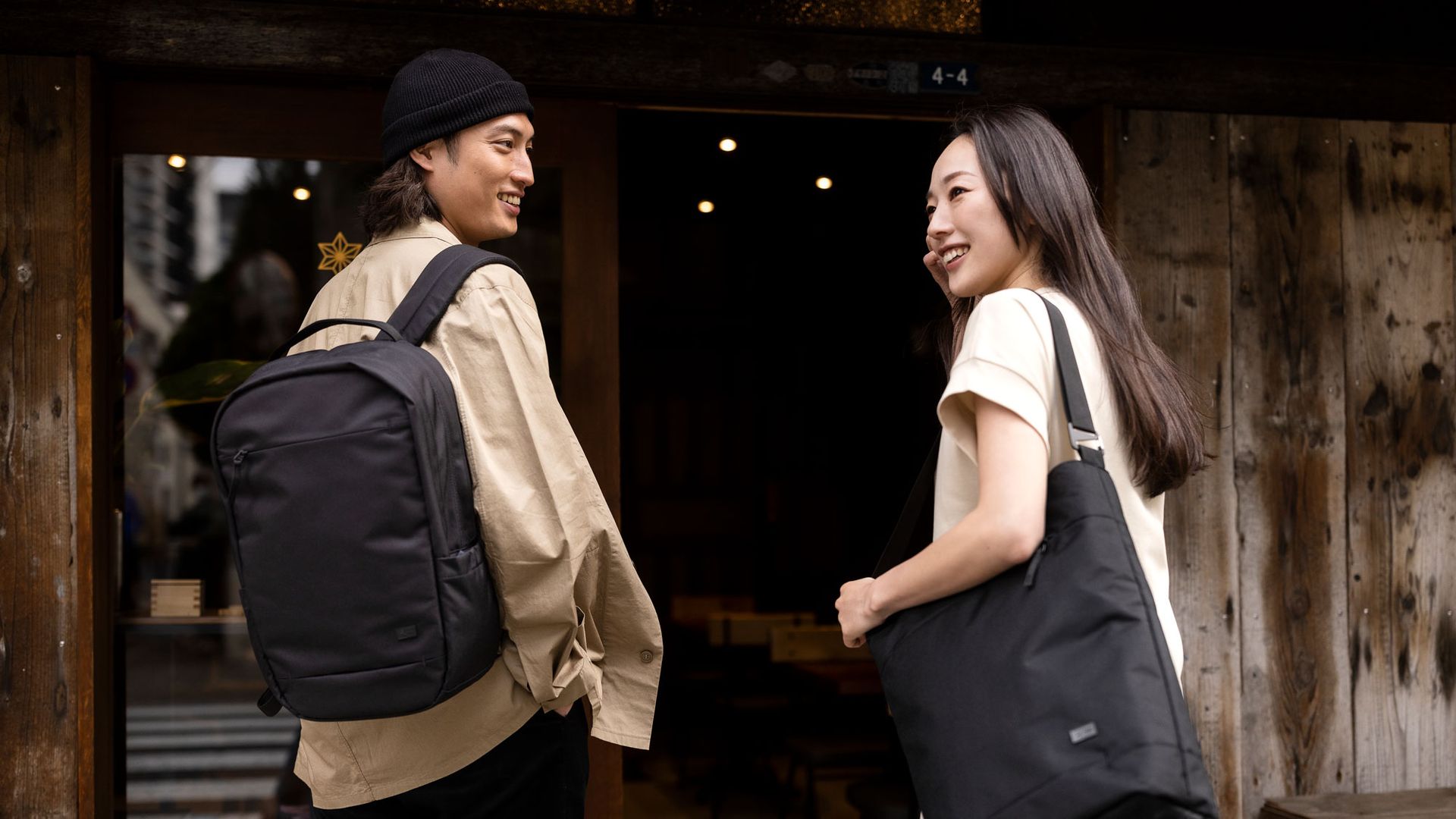 A man and woman with Case Logic bags stand outside a door.
