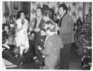 a black and white family of a group of people playing musical instruments near a Christmas tree inside of a home